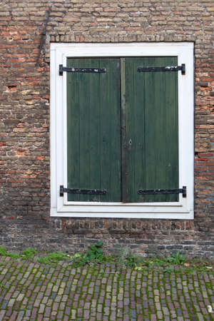 Closed antique green shutters on a window in Rotterdam in the Netherlandsの写真素材