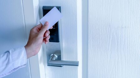 Hand holding key card using electronic card for access hotel room.の写真素材