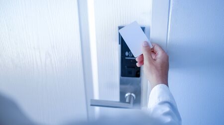 Hand holding key card using electronic card for access hotel room.の写真素材