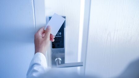 Hand holding key card using electronic card for access hotel room.の写真素材