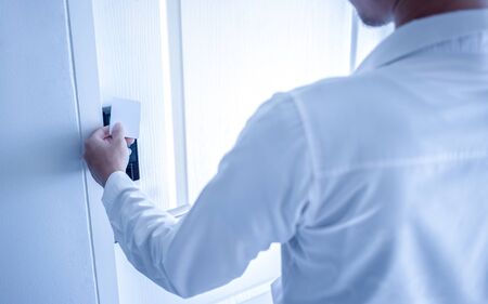 Hand holding key card using electronic card for access hotel room.の写真素材