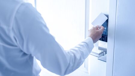 Hand holding key card using electronic card for access hotel room.の写真素材