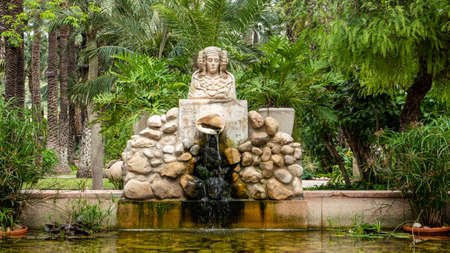 Fountain of woman bust among vegetationの写真素材