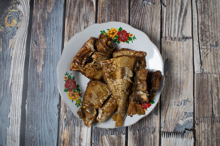 Golden brown fried fish arranged on a rustic wooden table backdrop.の写真素材