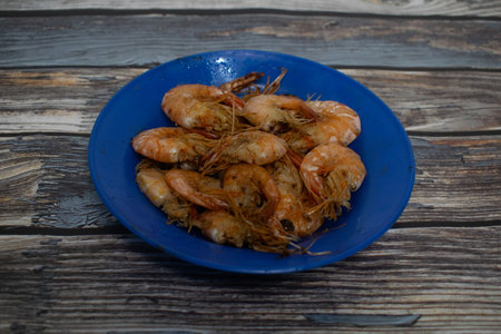A portion of fried shrimp with the shell on, placed on a blue plate.の写真素材