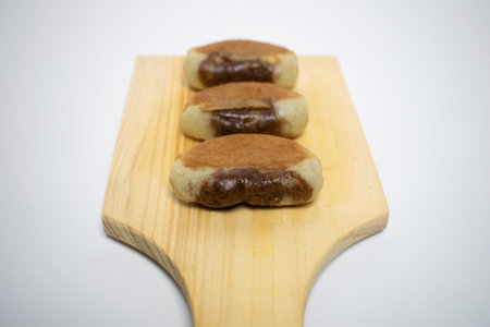 Homemade brown and white snacks on a minimalist wooden board, perfect for afternoon tea.の写真素材
