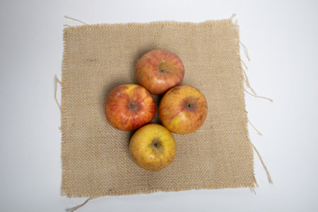 Rustic apples arranged on natural burlap.の写真素材
