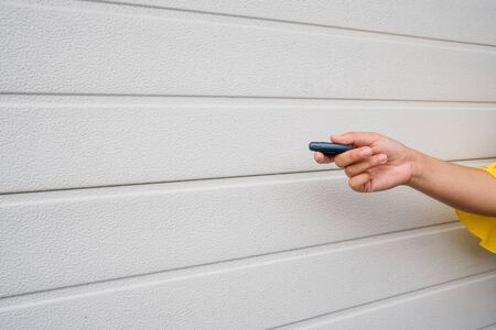 Garage door PVC. Hand use remote controller for closing and opening garage doorの写真素材
