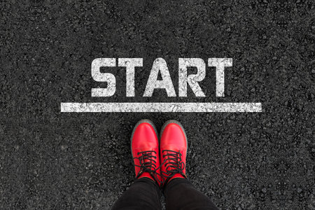 Start. Woman with boots is standing next to line and word START