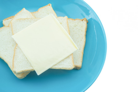 Slice of bread with cheese on blue plate with white background