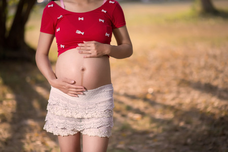 Image of pregnant woman touching her belly with handsの写真素材