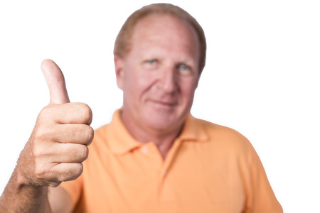 Handsome old man in orange polo-shirt shows thumb upの写真素材