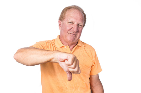 Handsome old man in orange polo-shirt shows thumb down