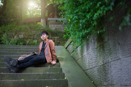 Young man sitting, loneliness, among the natureの写真素材