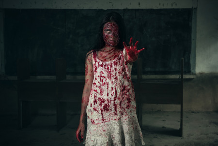 Suicidal girl in haunted school with cleaverの写真素材