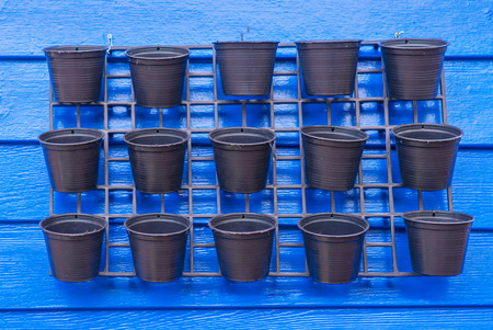 Empty Hanging flower pot against blue wallの写真素材