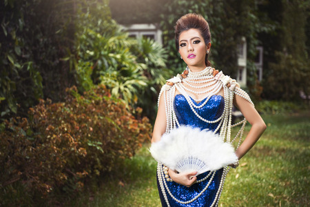 Beautiful lady in luxury blue dress with pearlの写真素材