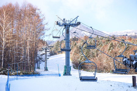 Snowboarders and skiers riding up a ski lift