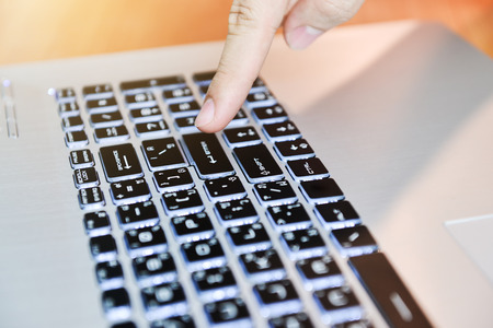 Man's hands typing on laptop keyboardの写真素材