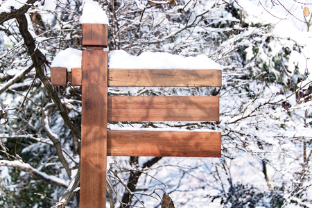 Wooden Sign in the Forest, covered with snowの写真素材