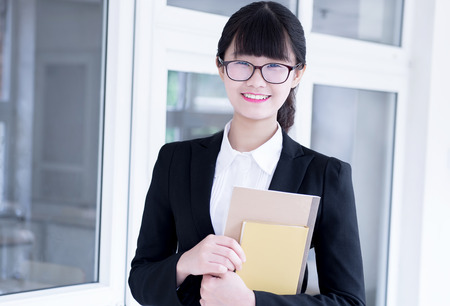 Modern business woman in the office, holding notebooksの写真素材