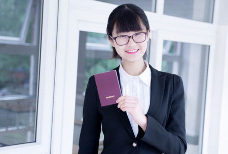 Modern business woman in the office, holding passportの写真素材