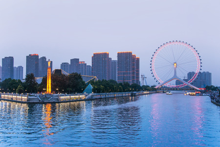 TIANJIN, CHINA - JUL 04, 2016: Tianjin is a metropolis in northern coastal China, tall giant Ferris wheel built above the Yongle Bridge, over the Hai River in Tianjin. JULY 04, 2016のeditorial素材