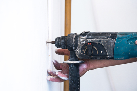 close up of electric drill making hole in a wall: repair, building and home conceptの写真素材