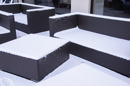 Snow covered chairs in gardenの写真素材