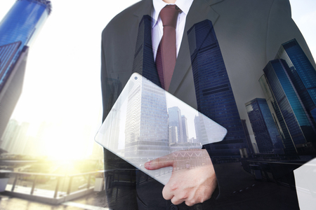 Business man holding tablet on blurry background.の写真素材