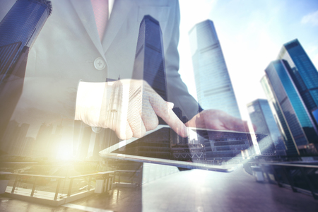 Business man holding tablet on blurry background.の写真素材