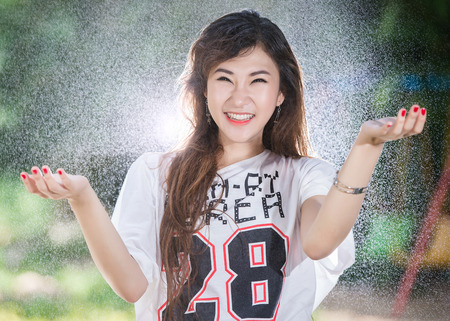 Happy girl is playing water in actionの写真素材