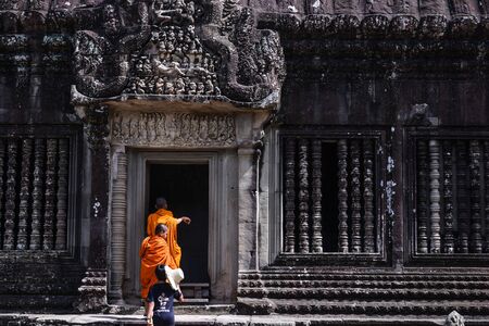 SIEM REAP, CAMBODIA - AUG 04, 2017: Buddhist monk in reddish yellow robes in one of the famous temples of Angkor Wat, Siem Reap, Cambodiaのeditorial素材