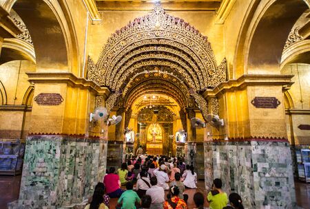 MANDALAY, MYANMAR - JUL 17, 2018 : Senior monk wash the face of Mahamuni Buddha image at Mahamuni temple. the most highly revered Buddha image in the country.のeditorial素材
