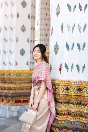 Beautiful Asian girl in Thai traditional costume at templeの写真素材