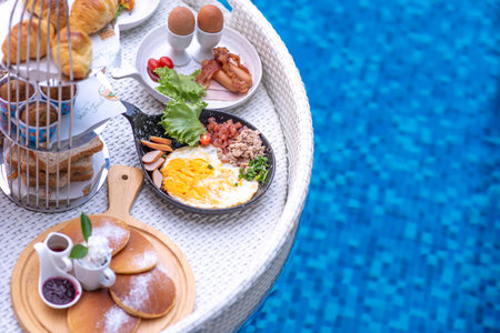 Breakfast in swimming pool, floating breakfast in villa resort. relaxing in calm pool water, healthy breakfast and tropical fruit.の写真素材