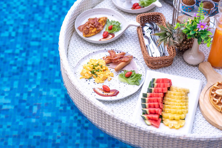 Breakfast in swimming pool, floating breakfast in villa resort. relaxing in calm pool water, healthy breakfast and tropical fruit.の写真素材
