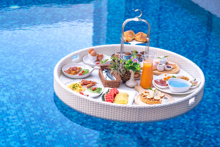 Breakfast in swimming pool, floating breakfast in villa resort. relaxing in calm pool water, healthy breakfast and tropical fruit.の写真素材