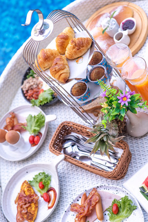 Breakfast in swimming pool, floating breakfast in villa resort. relaxing in calm pool water, healthy breakfast and tropical fruit.の写真素材