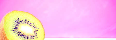Cut, sliced fresh kiwi isolated overlay with bokeh, blurred acrylic pink background. Copy space for text or product display. Middle-top view.の写真素材