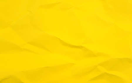 Vivid colorful wrinkled crumpled calendula, marigold yellow blank paper texture abstract background.の写真素材