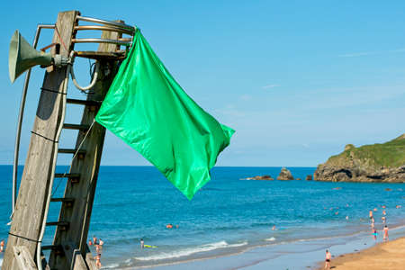 green flag on spanish beach next to the beach lookout postの写真素材