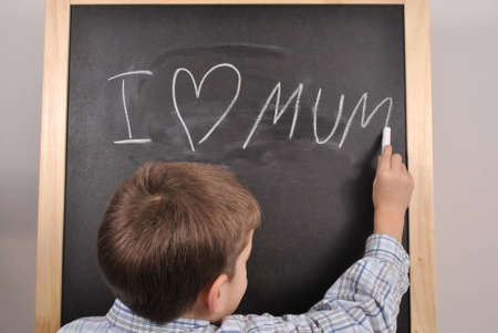 The little boy is presenting his feeling on the blackboardの写真素材