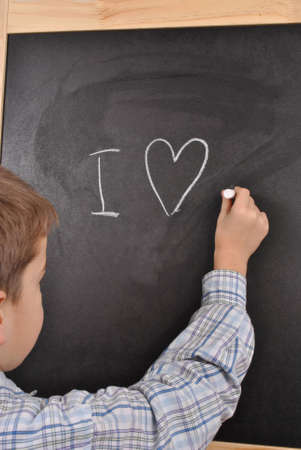 The young  boy is writing on blackboard his emotionの写真素材