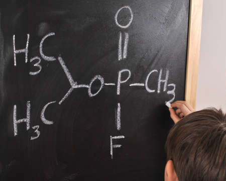 The student is solving the chemical reactions on the blackboard