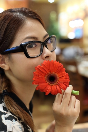 Asian Girl with Glasses Holding Flowerの写真素材