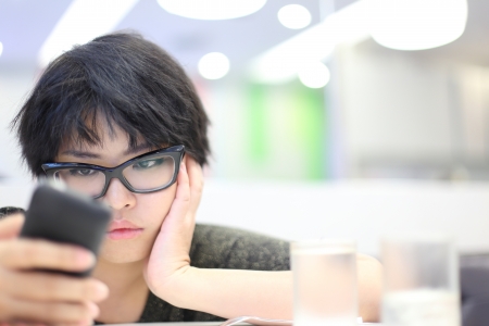 Short Hair Girl Looking Mobile Phone and Feeling Unhappyの写真素材