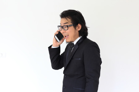 The Asian businessman talking with his smartphone.の写真素材