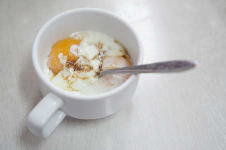 The soft-boiled eggs in the white mug.の写真素材