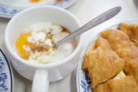 The soft-boiled eggs in the white mug.の写真素材